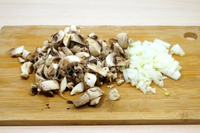 Чтобы приготовить яичный рулет с грибами, нужно 150 грамм свежих грибов шампиньонов мелко нарезать, луковицу измельчить.