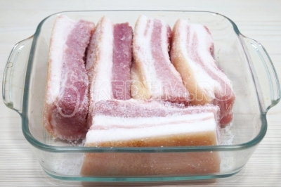 Выложить в форму кусочки сала.