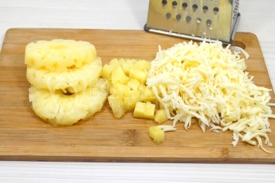 300 грамм консервированных ананасов нарезать кубиками, 100 грамм сыра натереть крупной на терке.