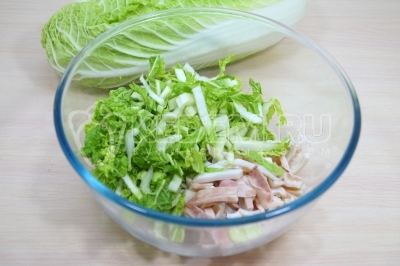 В большой миске смешать кальмары и капусту.