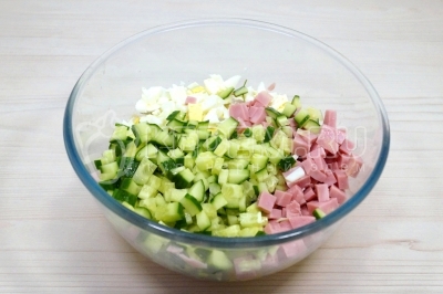 Добавить кубиками нарезанные свежий огурец и 150 грамм кубиками нарезанной ветчины.
