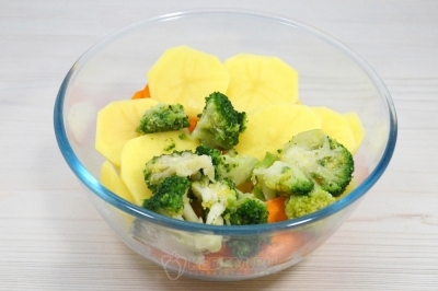 В миске смешать картофель, морковь и 150 грамм размороженной капусты брокколи.