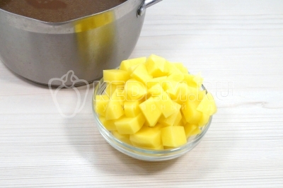 В кастрюлю с бульоном добавить 2 картофелины нарезанные кубиком. Варить 5-7 минут.