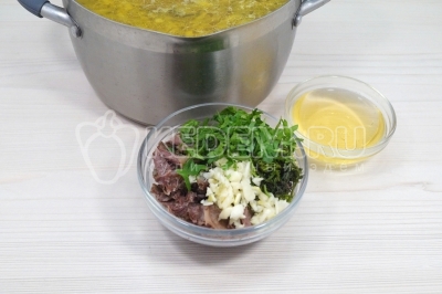 Добавить мясо с костей, мелко нашинкованную зелень и 50 миллилитров рассола от огурцов. На самом маленьком огне готовить еще 5-7 минут.