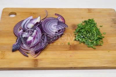 Чтобы приготовить селедку в горчичном маринаде, нужно полукольцами нашинковать одну красную луковицу. Зелень петрушки измельчить.