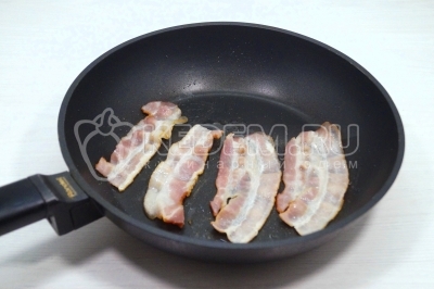 Сковороду разогреть на среднем огне. Выложить бекон и обжарить бекон с каждой стороны 2 минуты. Снять бекон на тарелку со сковороды.