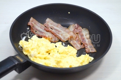 Снять с огня. Убрать скрэмбл на одну сторону сковороды и подогреть бекон с другой стороны, пока сковорода горячая.