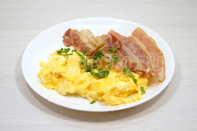 Разложить скрэмбл по тарелкам и украсить зеленью петрушки.