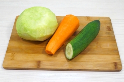 Чтобы приготовить салат с редькой, морковью и огурцом, нужно редьку, морковь очистить. Срезать хвостики у огурца.