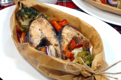 Горбуша запеченная в духовке с овощами в лодочках из пергамента готова. Переложить лодочки на тарелки и подавать к столу.