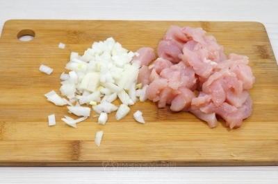 Нарезать мелко 1 луковицу и кусочками 200 грамм куриного филе.