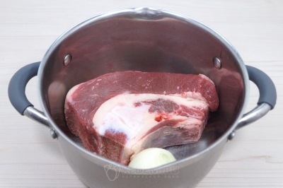 Сложить в кастрюлю грудинку и луковицу. Добавить 2, 5 литра воды и варить до закипания.