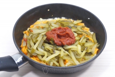 Добавить нарезанные огурцы и 2 столовые ложки томатной пасты. Готовить помешивая еще 3-4 минуты.