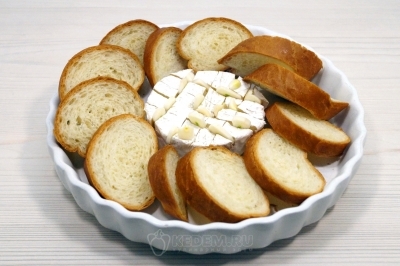 В форму для запекания выложить сыр и ломтики багета.