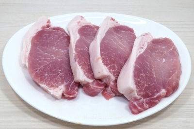 Чтобы приготовить мясо с квашеной капустой в духовке, нужно карбонат свинины нарезать ломтиками.